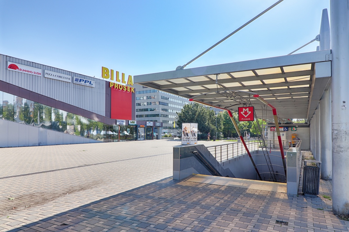 Vstup do stanice metra Prosek s obchodním centrem v pozadí