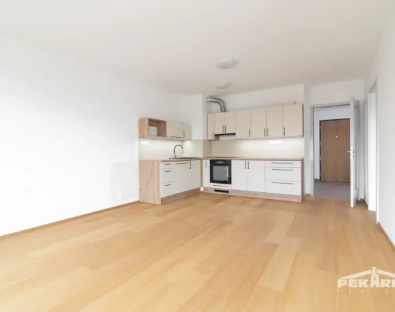 Pohled od oken na obývací část a kuchyňský kout